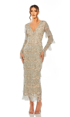 A woman stands in heels against a white background, wearing the Long Sleeve Beaded Formal Dress: Mac Duggal 93861—a tea-length silver gown with fringe detail and light-hued long sleeves for an elegant formal look.