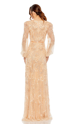 A woman with brown hair in a low ponytail models the Mac Duggal 93930 Long Sleeve Beaded Formal Gown, an elegant nude-colored dress with intricate beading and embroidery, seen from the back against a white background.