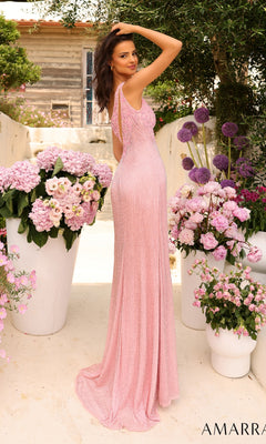 A woman wearing the Asymmetrical One-Shoulder Long Prom Dress 94013 stands outdoors between large white planters filled with pink and purple flowers.