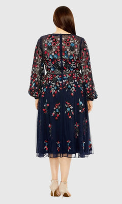 A woman is shown from the back wearing the Mac Duggal 94050, a plus-size cocktail dress in navy blue featuring knee-length hem, colorful floral beadwork, and sheer long sleeves.