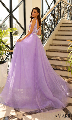 A woman in the Amarra 94052 V-Neck Long Sequin Prom Ball Gown stands on a staircase, smiling over her shoulder. The sparkly lavender dress shimmers in natural light, with large windows and a decorative railing as the backdrop.