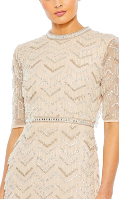 A woman wears the Mac Duggal Beaded Fringe Long Formal Dress 94071, a beige gown with sequin and bead chevron detailing, short sleeves, high neckline, and delicate beaded fringe for elegant flair.