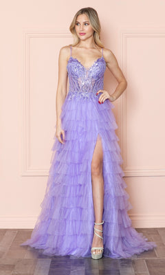 A woman models the Open-Back Long Ruffled Prom Dress: Poly USA 9408, featuring a lavender beaded v-neck bodice, spaghetti straps, sequin accents, and a tiered tulle skirt with slit, standing by a light pink wall on a wood floor.