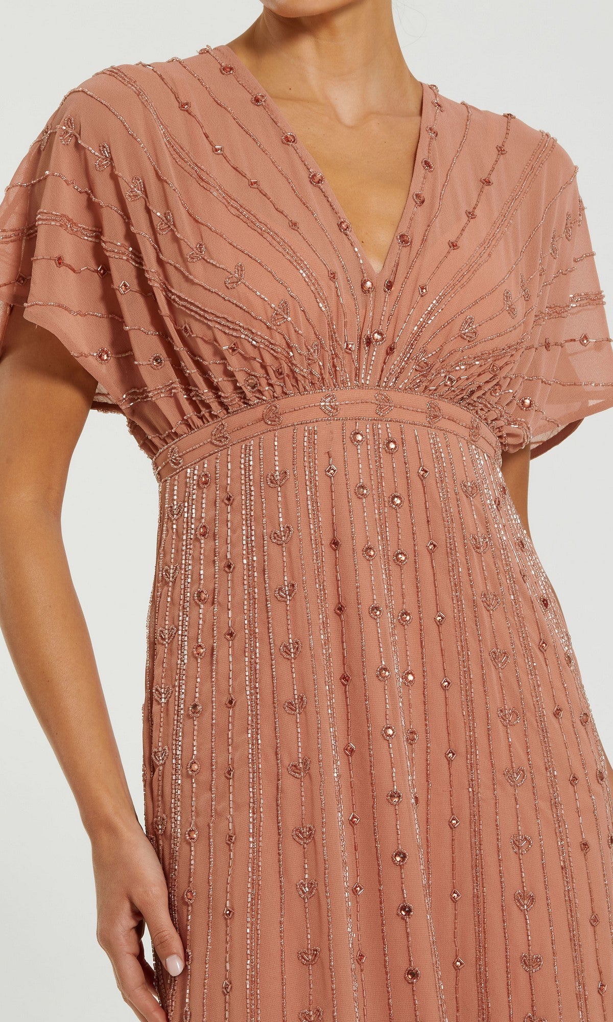 A person wearing the Mac Duggal 94149 long formal dress in dusty rose, featuring short sleeves, a beaded V-neckline, and vertical sequin detailing.