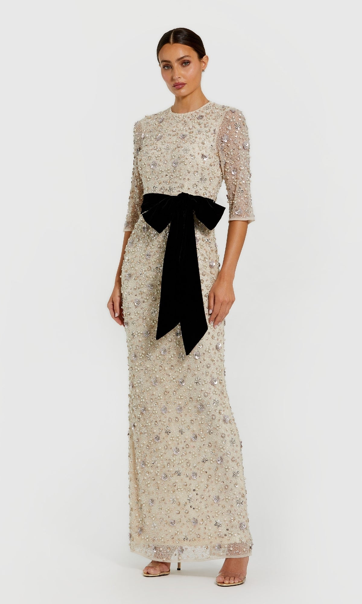 Woman wearing a Mac Duggal 94166 Beaded Oyster White Formal Gown with three-quarter sleeves and a large black waist bow, standing against a plain white background.