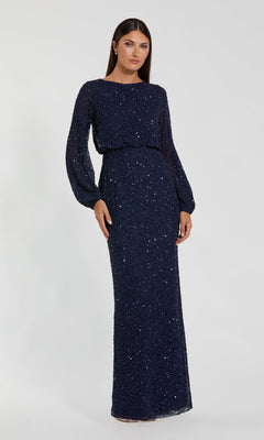 A woman stands against a plain light background, modeling the Mac Duggal 94203 Long Formal Dress in navy—a floor-length, long-sleeve sequin gown with a blouson bodice that perfectly embodies elegant, modest style.