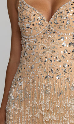 Close-up of the torso and part of one arm of the Long Formal Dress: Mac Duggal 94207, featuring beaded and sequined nude fabric with silver and crystal embellishments, as well as fringe details.
