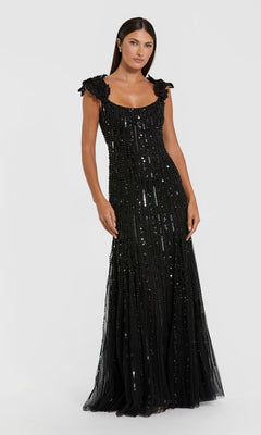A woman stands in the Mac Duggal 94223 long formal dress, a floor-length, sleeveless black gown featuring mesh fabric with sequins and textured shoulder details, set against a plain white background.