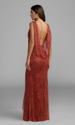 A woman stands against a plain gray background wearing the Cowl-Back Floral Formal Gown (Mac Duggal 94263), a floor-length, sleeveless red sequin dress featuring a draped, low-cut back.