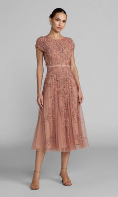 Woman wearing the Mac Duggal 94339 Midi Wedding Guest Dress in Rosewood, featuring an a-line silhouette with floral embroidery and a tulle overlay, ideal for wedding receptions, standing against a plain gray background.