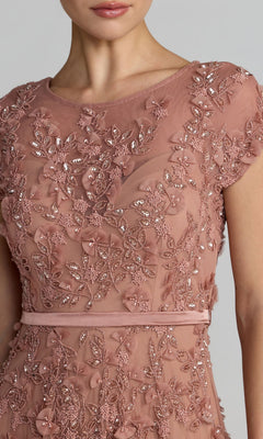 A woman wears the Mac Duggal 94339 midi wedding guest dress, featuring dusty pink fabric, floral embroidery, sequins, cap sleeves, and a thin waist belt—ideal for a charming wedding reception look.