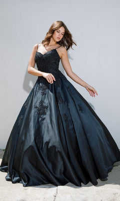 A woman poses against a plain, light-colored wall in the Classic Long Prom Ball Gown: Eureka 9500, featuring black lace detailing and a chic lace-up back.