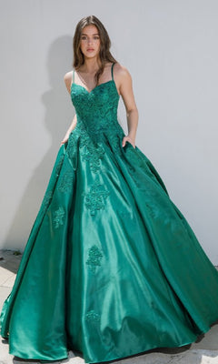 A woman in the Eureka 9500 Classic Long Prom Ball Gown—a green dress with thin straps, a lace-up back, and embroidered details—stands against a plain white background.