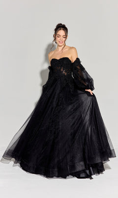 A woman wears the Eureka 9505G Long Sleeve Strapless Prom Ball Gown, featuring sheer off-shoulder sleeves and black embroidery, standing against a plain light background.