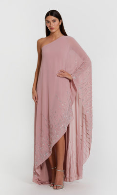 A woman stands against a plain white background wearing the Mac Duggal 9517 long formal dress in antique rose—an elegant one-shoulder kaftan gown embellished with silver sequin detailing.