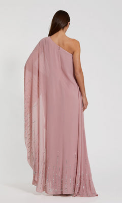 A person is wearing the Long Formal Dress: Mac Duggal 9517, a one-shoulder kaftan gown in dusty pink featuring sequin details, shown from the back against a plain light background.