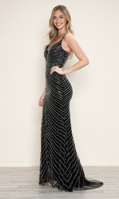 A woman stands sideways, smiling in the Cut-Out Long Beaded Prom Dress (Poly USA 9530), a floor-length black sleeveless gown with silver sequin patterns, set against a light background.