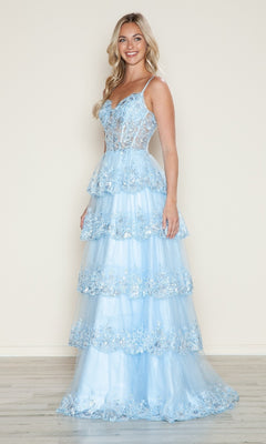 A woman smiles while wearing the blue Long Glitter-Lace Tiered Prom Dress (Poly USA 9548) featuring spaghetti straps and a semi-sheer bodice, standing against a plain light background.