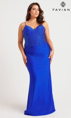 A woman in the Long Plus-Size Prom Dress: Faviana 9555, a fitted royal blue gown with a corset bodice and sparkling bead details, stands against a white background with the Faviana logo in the top right corner.