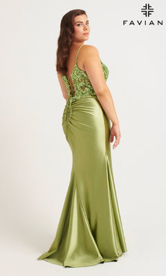 A woman in a fitted, light green satin Faviana 9563 plus-size prom dress with lace bodice detailing poses facing away from the camera. The FAVIAN designer logo appears in the top right corner.