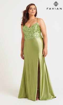 A woman stands against a plain background in the Faviana 9563 Long Plus-Size Prom Dress, a light green satin gown with floral lace details, thin straps, and a thigh-high slit. The Faviana logo appears at the top right corner.