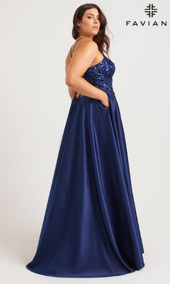Woman wearing Faviana 9578, a floor-length plus-size prom dress in dark blue featuring a sequin-embroidered bodice and pockets, posing in profile against a plain background with the Faviana logo in the top right corner.