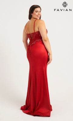 A woman in the Faviana 9592 Long Plus-Size Prom Dress, a fitted red gown with thin straps and an adjustable tie back, stands facing slightly away from the camera. "FAVIANA" and its logo are visible in the top right corner.