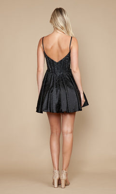 A woman with blonde hair models the sleeveless black Poly USA 9594 Sparkly Homecoming Dress with pockets and beige heels, shown from the back against a plain beige background.