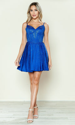 A woman stands against a light background wearing the Sparkly Homecoming Dress with Pockets: Poly USA 9594, a blue, sleeveless, knee-length dress with glittering details and nude heels.