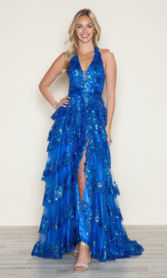 Indoors, a woman models the Poly USA 9618 long prom dress—a sleeveless, deep blue sequin gown with tiered ruffles and a high slit—styled with silver heels.