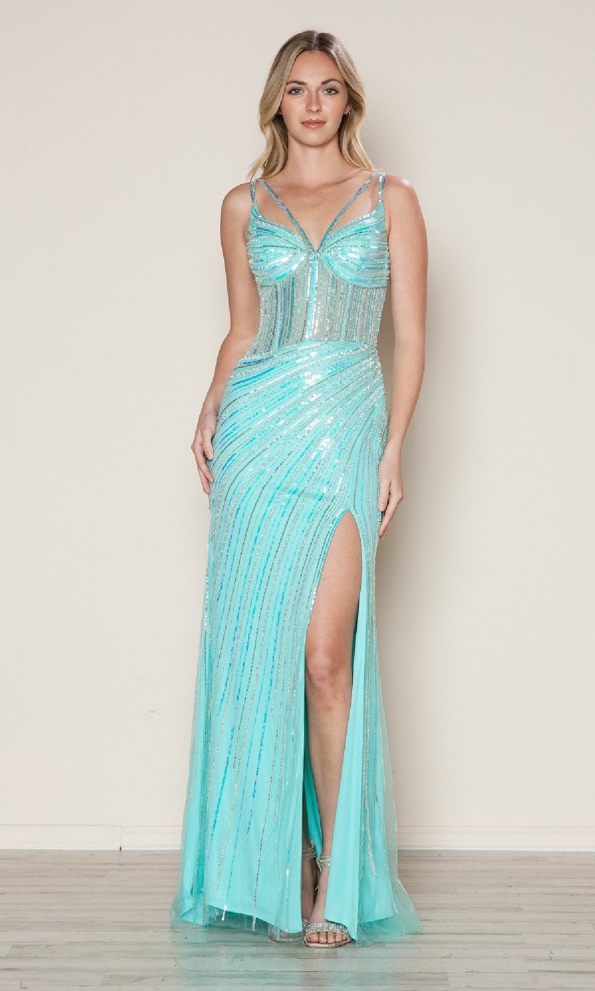 A woman models the Sheer-Bodice Long Sequin Prom Dress (Poly USA 9664) in light blue, featuring thin straps and a thigh-high slit, standing against a plain background.