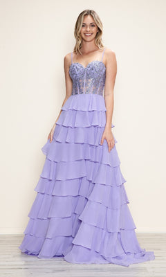 A woman stands smiling in the Long Tiered Corset Prom Dress: Poly USA 9698 in lavender, featuring a fitted corset-style bodice, thin straps, and a tiered a-line skirt, set against a simple light background.