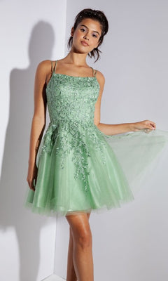 A woman stands indoors wearing the Eureka 9727 Lace-Up Short Prom Dress, a light green, sleeveless A-line party dress with floral embroidery and a tulle skirt.