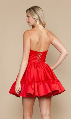 A woman models the Ruffled Strapless Short Hoco Dress: Poly USA 9782, featuring a ruffled skirt and lace-up back, against a plain beige background.