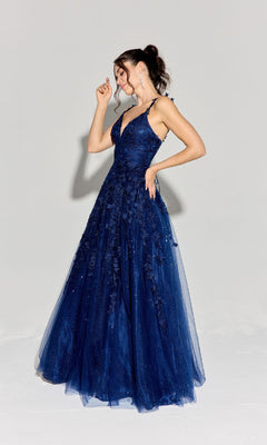 A woman poses gracefully against a plain light background in the Eureka 9858 Embroidered-Lace Long Prom Dress, featuring a deep blue hue and delicate lace details.