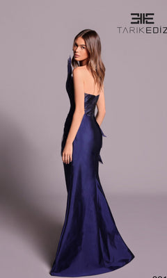 A woman models the Tarik Ediz 99102 long formal dress, a dark blue strapless jacquard taffeta gown with a fitted bodice, standing against a plain background. "Tarik Ediz" is displayed in the top right corner.