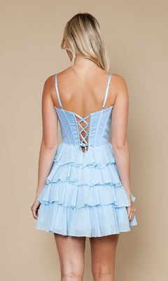 A woman stands with her back to the camera against a beige background, wearing the Poly USA 9916 Short Ruffled Homecoming Dress featuring a lace-up back.