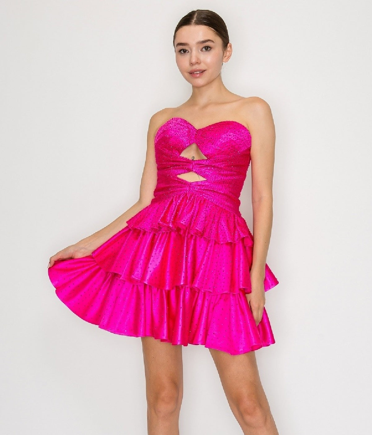 A woman models the Poly USA 9944 short homecoming dress in hot pink, showcasing its strapless heart-shaped bust, front cutout, and tiered fit-and-flare mini skirt against a simple light background.