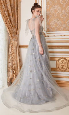 A woman in the Shoulder-Bow Long Corset Prom Ball Gown A0824—a sheer, light blue gown with gold accents and corset bodice—stands in an ornate gold and cream room, looking over her shoulder.