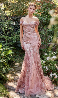 A woman stands outdoors amid lush greenery in the Off-Shoulder Long Sequin Mermaid Prom Dress A1107, blush pink with metallic details and a fitted silhouette, creating an elegant scene.