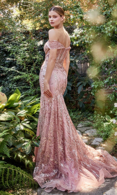 A woman stands outdoors on a stone path surrounded by lush greenery, wearing the Off-Shoulder Long Sequin Mermaid Prom Dress A1107, featuring a shimmering design and elegant long train.