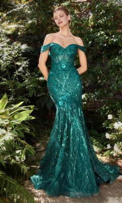 A woman stands outdoors in a garden, wearing the Off-Shoulder Long Sequin Mermaid Prom Dress A1107 in emerald green for a glamorous touch.