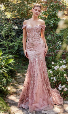 A woman stands outdoors in the Off-Shoulder Long Sequin Mermaid Prom Dress A1107, a fitted pink gown with sequin details and a slight train, surrounded by greenery and flowers.