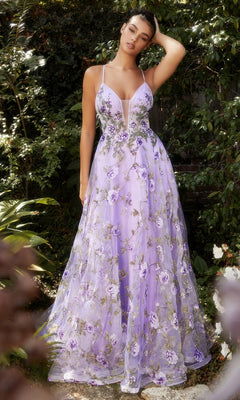 A woman stands outdoors surrounded by green foliage, wearing the Lilac Purple Floral-Print Long Prom Dress A1135 with a deep neckline and floral embroidery.