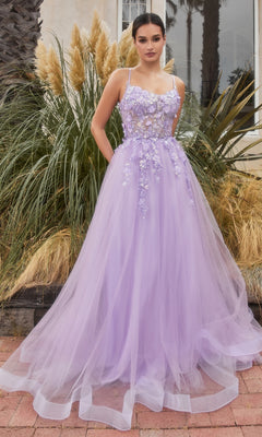 A woman stands before tall grasses and a building, wearing the Flower-Embellished Long Tulle Prom Ball Gown A1142 in lavender, featuring delicate 3D floral details and a sheer waist.