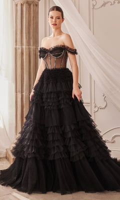 A woman indoors wears the Pastel Off-the-Shoulder Ruffled Ball Gown A1150, featuring ruffles, a sheer corset bodice, and a tiered skirt.