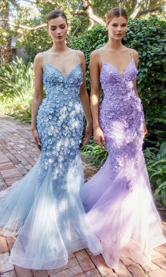 Two women stand outdoors in floor-length, mermaid-style Floral Beaded Long Mermaid Prom Dress A1201 gowns—one in blue, the other in lavender—featuring thin straps and beautiful 3-D floral appliques.