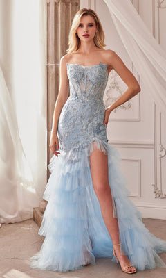 A woman stands indoors wearing the Strapless Fitted Ruffle Prom Dress A1255 in light blue lace and tulle, featuring a high slit and tiered ruffle skirt, styled with nude heels.