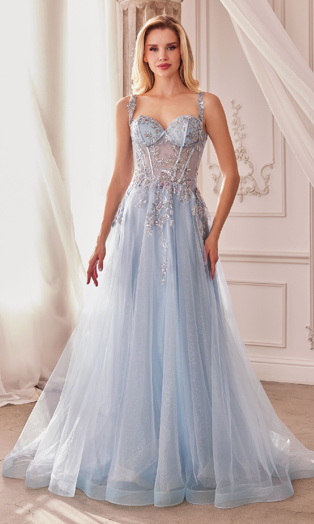 A woman stands indoors wearing the Long Pastel A-Line Prom Dress: Andrea & Leo 1258, featuring a fitted embellished bodice and sheer tulle skirt.