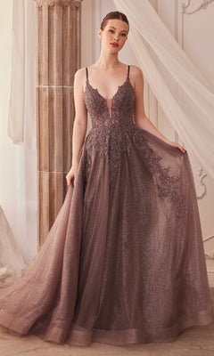 A woman stands indoors beside a column, wearing the Sage Green Long Glitter-Tulle Prom Dress A1261, which features a floor-length silhouette and a sparkling tulle skirt.